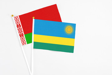 Rwanda and Belarus stick flags on white background. High quality fabric, miniature national flag. Peaceful global concept.White floor for copy space.