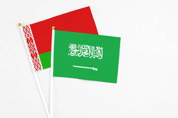 Saudi Arabia and Belarus stick flags on white background. High quality fabric, miniature national flag. Peaceful global concept.White floor for copy space.
