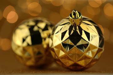 Christmas and New Year winter festive background.Golden balls christmas decor on brown blurred bokeh background.Christmas tree decor.Phone christmas wallpaper