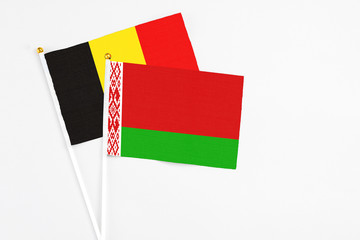 Belarus and Belgium stick flags on white background. High quality fabric, miniature national flag. Peaceful global concept.White floor for copy space.