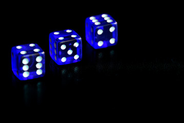 Blue dice scattered on a black surface close-up. Gambling background
