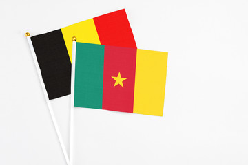 Fototapeta premium Cameroon and Belgium stick flags on white background. High quality fabric, miniature national flag. Peaceful global concept.White floor for copy space.