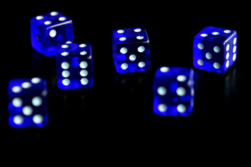 Blue dice scattered on a black surface close-up. Gambling background