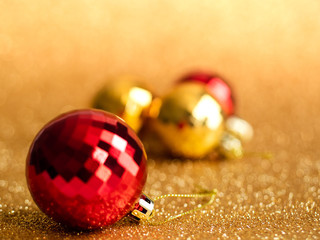 Golden christmas ball on gold glitter background.
