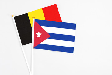 Cuba and Belgium stick flags on white background. High quality fabric, miniature national flag. Peaceful global concept.White floor for copy space.