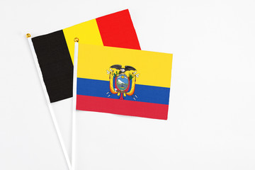 Ecuador and Belgium stick flags on white background. High quality fabric, miniature national flag. Peaceful global concept.White floor for copy space.