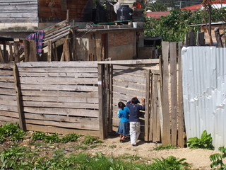 Local children peeking in through the gaps in the wooden doors, San Cristobal de Las Casas, Mexico
