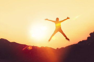 Fototapeta na wymiar Happy man jumping at top of mountain with sunset sky abstract background.