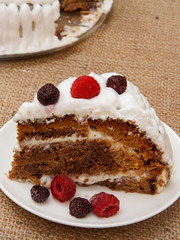 Sliced homemade biscuit cake decorated with whipped cream on plates.