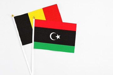 Libya and Belgium stick flags on white background. High quality fabric, miniature national flag....