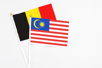 Malaysia and Belgium stick flags on white background. High quality fabric, miniature national flag. Peaceful global concept.White floor for copy space.