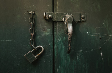 Old master key rusty and key unlock on green retro metal sheet door