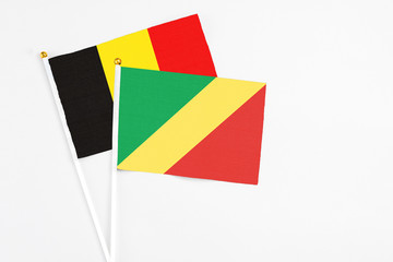 Republic Of The Congo and Belgium stick flags on white background. High quality fabric, miniature national flag. Peaceful global concept.White floor for copy space.