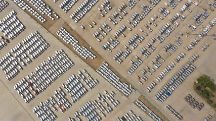 China economy and industry - overhead aerial view of massive parking lot filled with newly produced vehicles at car manufacturing company in Qingdao - Powered by Adobe