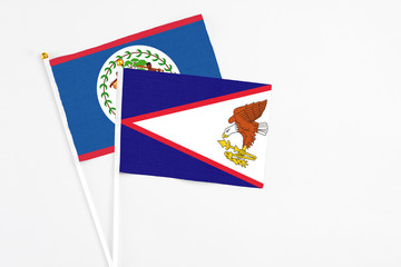 American Samoa and Belize stick flags on white background. High quality fabric, miniature national flag. Peaceful global concept.White floor for copy space.