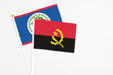 Angola and Belize stick flags on white background. High quality fabric, miniature national flag. Peaceful global concept.White floor for copy space.