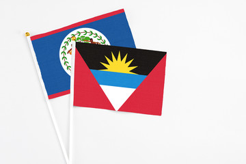 Antigua and Barbuda and Belize stick flags on white background. High quality fabric, miniature national flag. Peaceful global concept.White floor for copy space.