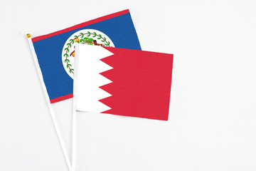 Bahrain and Belize stick flags on white background. High quality fabric, miniature national flag. Peaceful global concept.White floor for copy space.