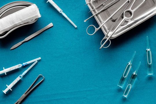 Plastic surgery instruments and tools with bandage on blue background top view frame copy space