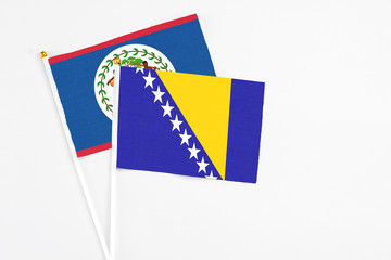 Bosnia Herzegovina and Belize stick flags on white background. High quality fabric, miniature national flag. Peaceful global concept.White floor for copy space.