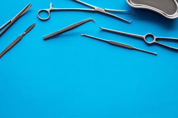 Plastic surgery. Instruments for beauty operations on blue background top view frame copy space