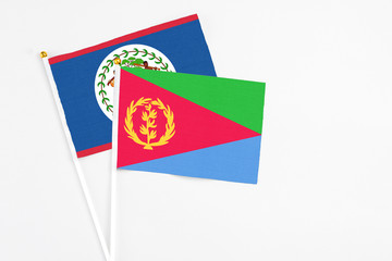 Eritrea and Belize stick flags on white background. High quality fabric, miniature national flag. Peaceful global concept.White floor for copy space.