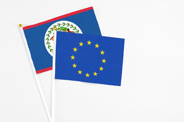 European Union and Belize stick flags on white background. High quality fabric, miniature national flag. Peaceful global concept.White floor for copy space.