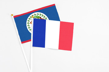 France and Belize stick flags on white background. High quality fabric, miniature national flag. Peaceful global concept.White floor for copy space.