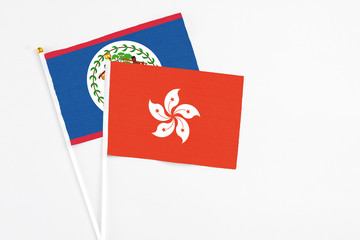 Hong Kong and Belize stick flags on white background. High quality fabric, miniature national flag. Peaceful global concept.White floor for copy space.