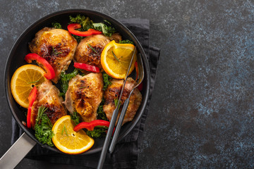 Pieces of chicken baked with oranges and red pepper.