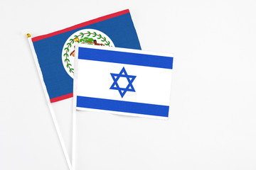 Israel and Belize stick flags on white background. High quality fabric, miniature national flag. Peaceful global concept.White floor for copy space.
