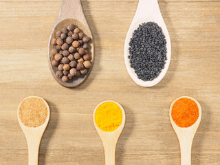 Allspice, black cumin, turmeric, masala, chili pepper on brown wooden background. Indian cuisine, ayurveda, naturopathy, modern apothecary concept