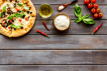 Obraz na płótnie Canvas Traditional italian food: pizza on dark wooden background top view copy space