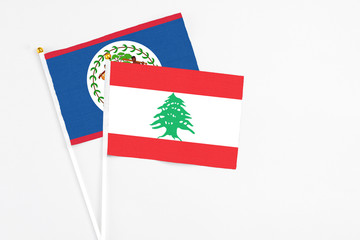 Lebanon and Belize stick flags on white background. High quality fabric, miniature national flag. Peaceful global concept.White floor for copy space.