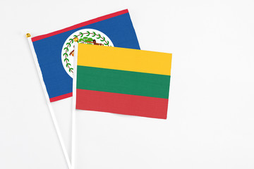 Lithuania and Belize stick flags on white background. High quality fabric, miniature national flag. Peaceful global concept.White floor for copy space.