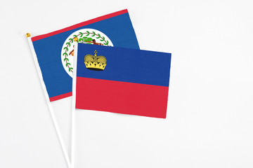 Liechtenstein and Belize stick flags on white background. High quality fabric, miniature national flag. Peaceful global concept.White floor for copy space.