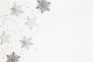 Christmas or winter composition. Frame made of silver snowflakes on white background. Christmas, winter, new year concept. Flat lay, top view, copy space