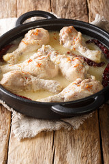Spicy festive chicken Rezala cooked in yogurt sauce close-up in a pan. vertical