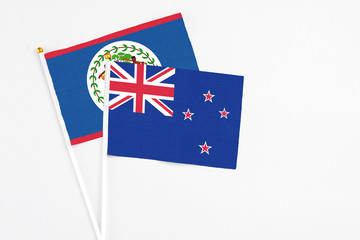 Fototapeta premium New Zealand and Belize stick flags on white background. High quality fabric, miniature national flag. Peaceful global concept.White floor for copy space.