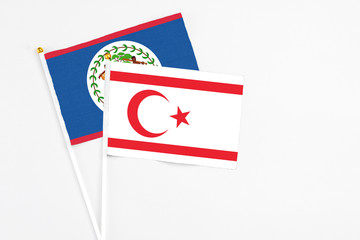 Northern Cyprus and Belize stick flags on white background. High quality fabric, miniature national flag. Peaceful global concept.White floor for copy space.