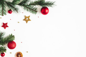 Christmas composition. Fir tree branches, red and golden decorations on white background....