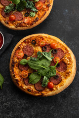 Freshly baked homemade pizza on a black background. View from above.