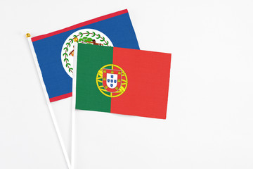 Portugal and Belize stick flags on white background. High quality fabric, miniature national flag. Peaceful global concept.White floor for copy space.