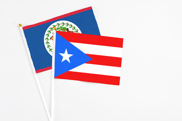 Puerto Rico and Belize stick flags on white background. High quality fabric, miniature national flag. Peaceful global concept.White floor for copy space.