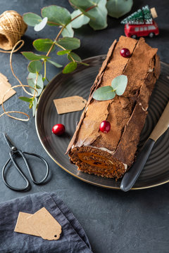 Buche de Noel. Traditional Christmas dessert, Christmas yule log cake with chocolate cream, cranberry. Copy space.