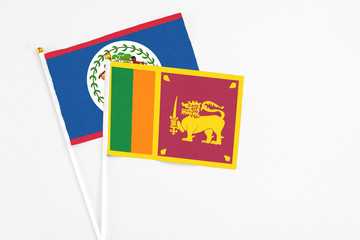 Sri Lanka and Belize stick flags on white background. High quality fabric, miniature national flag. Peaceful global concept.White floor for copy space.