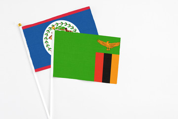 Zambia and Belize stick flags on white background. High quality fabric, miniature national flag. Peaceful global concept.White floor for copy space.
