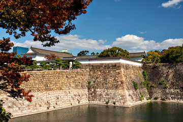 Fototapeta na wymiar Defensive stone wall of Osaka-jo castle in autumn