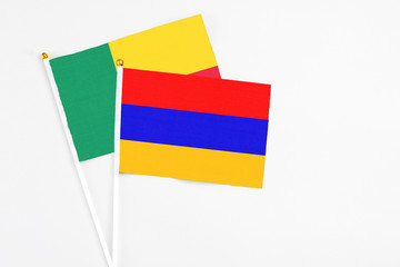 Armenia and Benin stick flags on white background. High quality fabric, miniature national flag. Peaceful global concept.White floor for copy space.