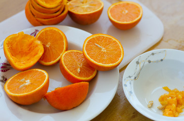 Fresh citrus orange halves on the plate and cuttimg board after making orange juice at home